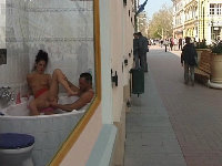 Neukend in de etalage van een drukke winkelstraat, iedereen kijkt vrolijk mee!